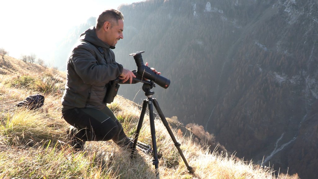 Bobo Audino intento a filmare il camoscio che appare nel video con il suo Smartphone accoppiato al Leica Apo Televid di Leica, tenuto a ingrandimento 50x