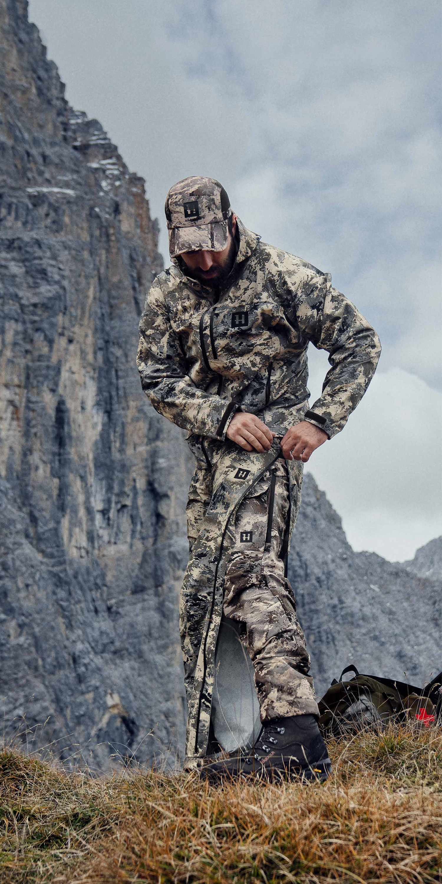 La giacca e i pantaloni del guscio, sotto i pantaloni leggeri e in testa il cappello della linea Härkila Mountain Hunter Expedition.